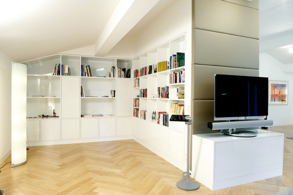 Large trendy open concept light wood floor living room library photo in Munich with white walls and a tv stand