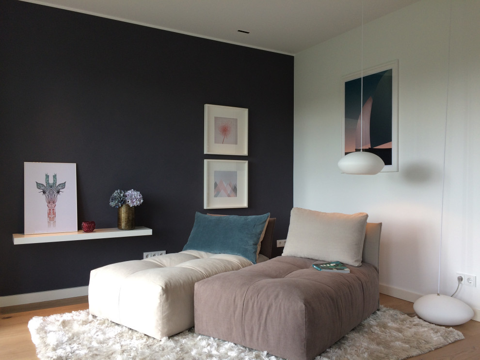 На фото: открытая гостиная комната среднего размера в современном стиле с с книжными шкафами и полками, синими стенами и светлым паркетным полом с