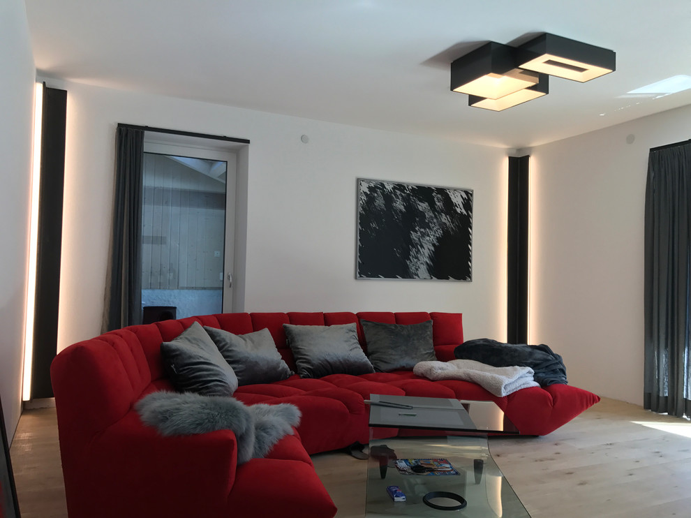 Imagen de sala de estar abierta contemporánea de tamaño medio con paredes blancas, suelo de madera clara y suelo marrón