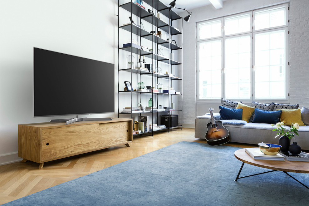 Mittelgroßes Modernes Wohnzimmer im Loft-Stil mit weißer Wandfarbe, braunem Holzboden, freistehendem TV und braunem Boden in Berlin