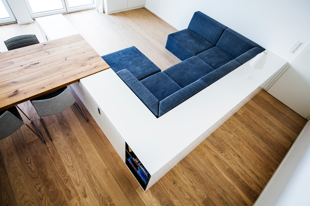 Mittelgroßes, Offenes Modernes Musikzimmer mit weißer Wandfarbe, braunem Holzboden, freistehendem TV und braunem Boden in München