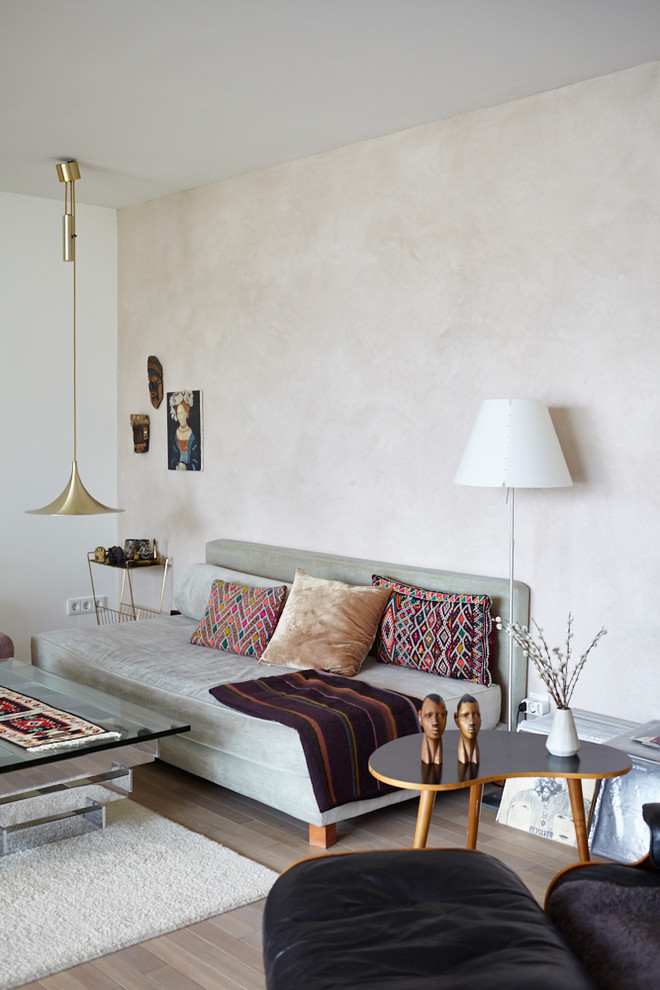 Immagine di un piccolo soggiorno design chiuso con pareti beige, pavimento in legno massello medio, nessun camino e pavimento marrone