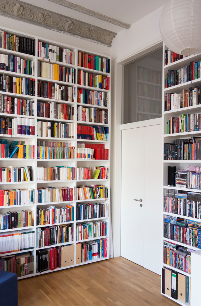 Foto di un ampio soggiorno contemporaneo chiuso con libreria, pareti bianche, pavimento in legno massello medio, parete attrezzata e pavimento beige