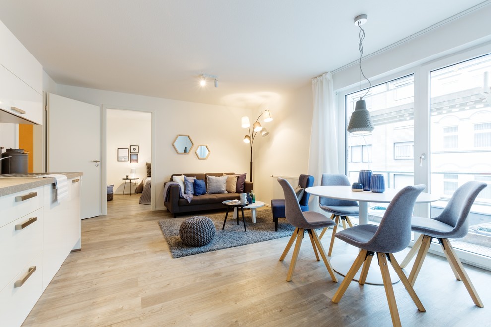 Skandinavisches Wohnzimmer mit weißer Wandfarbe, braunem Holzboden und braunem Boden in Düsseldorf