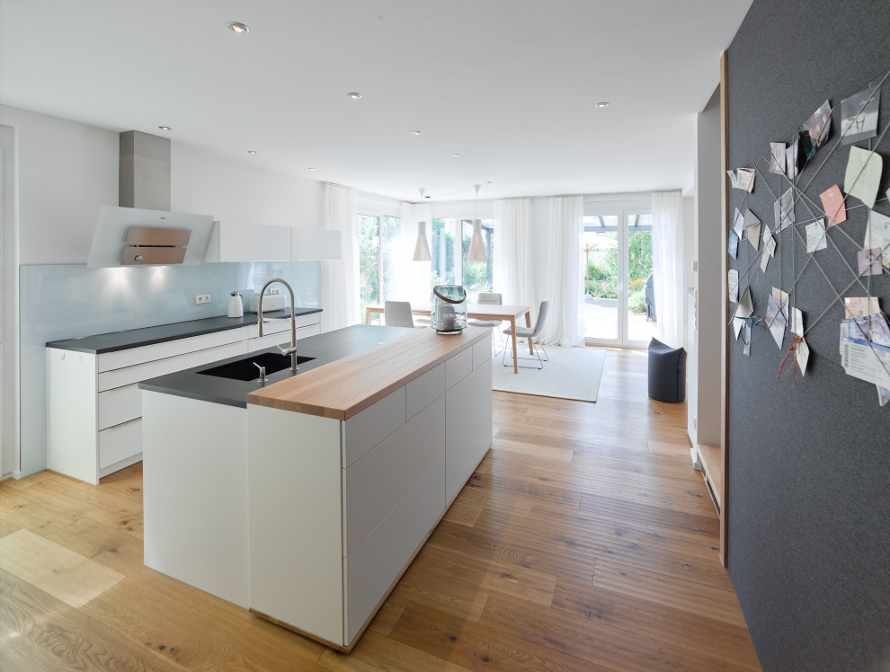 Mittelgroßes, Offenes Modernes Wohnzimmer mit weißer Wandfarbe, braunem Holzboden und braunem Boden in Stuttgart