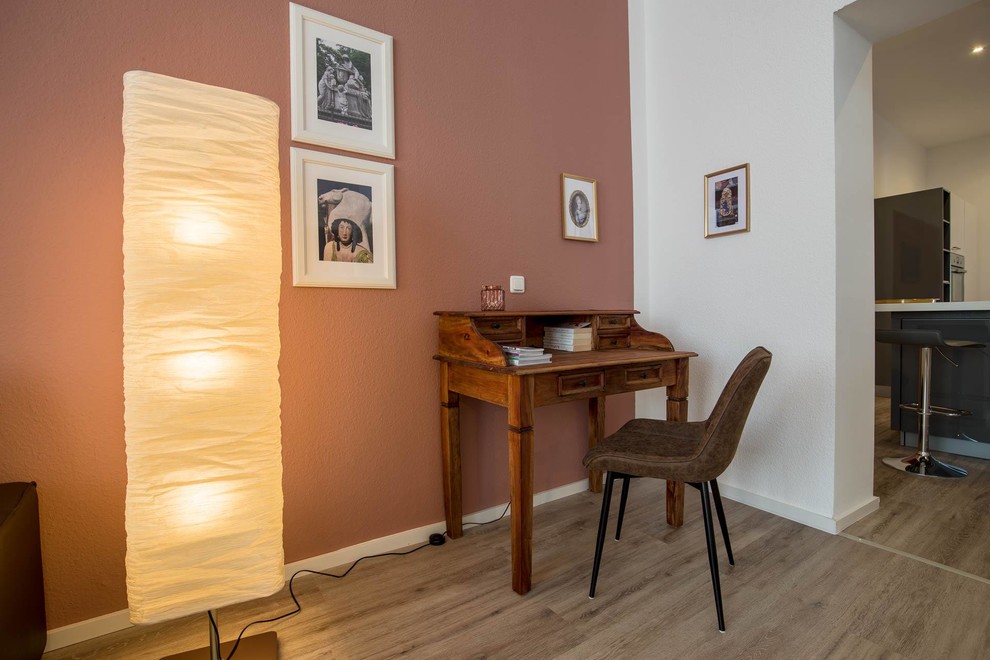 Kleines, Offenes Industrial Wohnzimmer mit roter Wandfarbe, Vinylboden, freistehendem TV und beigem Boden in Hannover