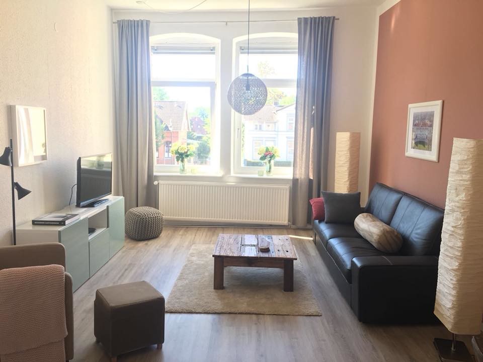 Kleines, Offenes Klassisches Wohnzimmer mit brauner Wandfarbe, freistehendem TV und beigem Boden in Hannover