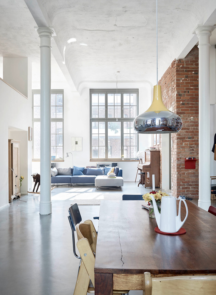 Foto di un ampio soggiorno industriale stile loft con sala formale, pareti grigie e pavimento in cemento