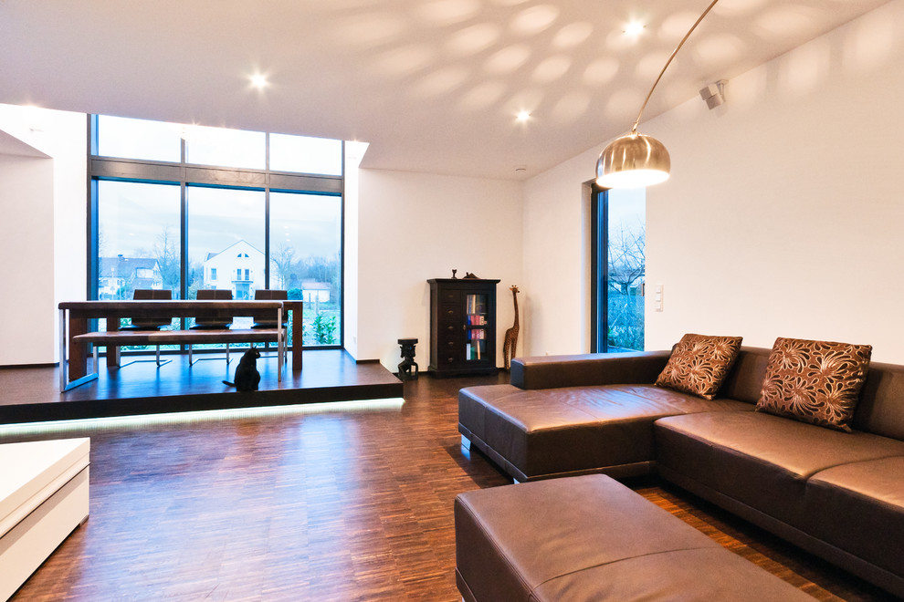 Großes, Offenes Modernes Wohnzimmer mit weißer Wandfarbe und dunklem Holzboden in Frankfurt am Main