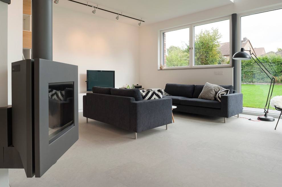 Immagine di un soggiorno minimal di medie dimensioni e aperto con pareti bianche e TV autoportante