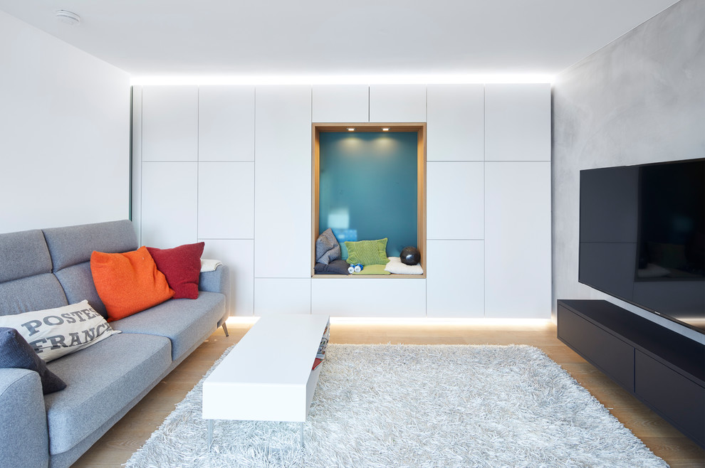 Example of a large trendy enclosed brown floor and light wood floor family room library design in Stuttgart with white walls, no fireplace and a wall-mounted tv