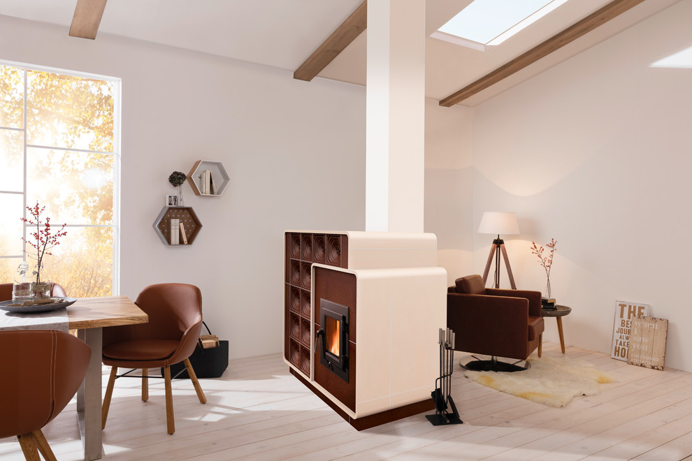 На фото: открытая гостиная комната среднего размера в современном стиле с печью-буржуйкой, белыми стенами, деревянным полом и фасадом камина из плитки