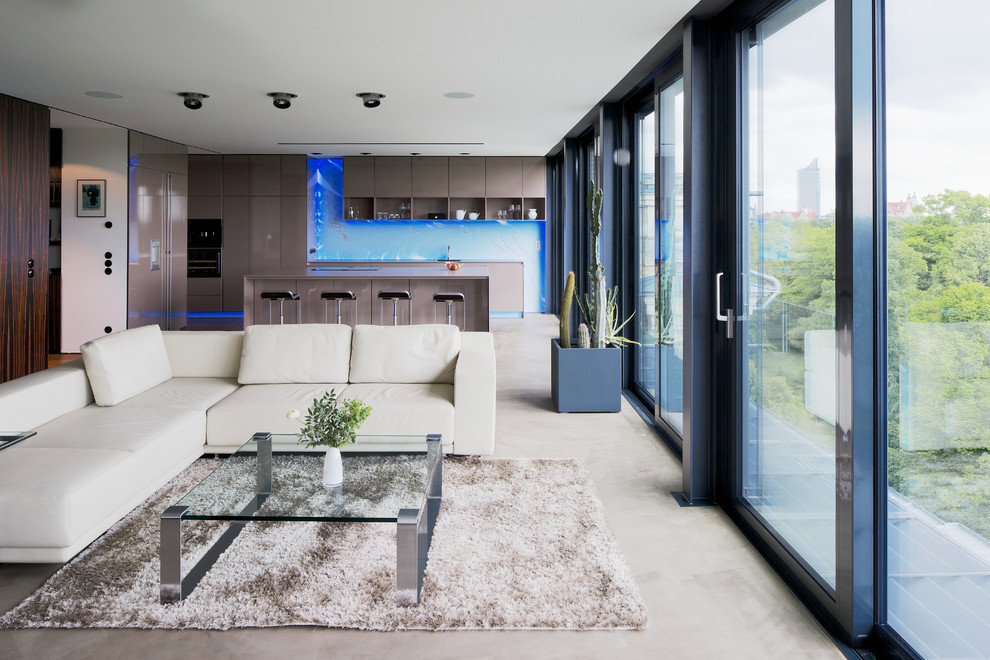 Идея дизайна: большая открытая гостиная комната в современном стиле с бетонным полом и белыми стенами без камина