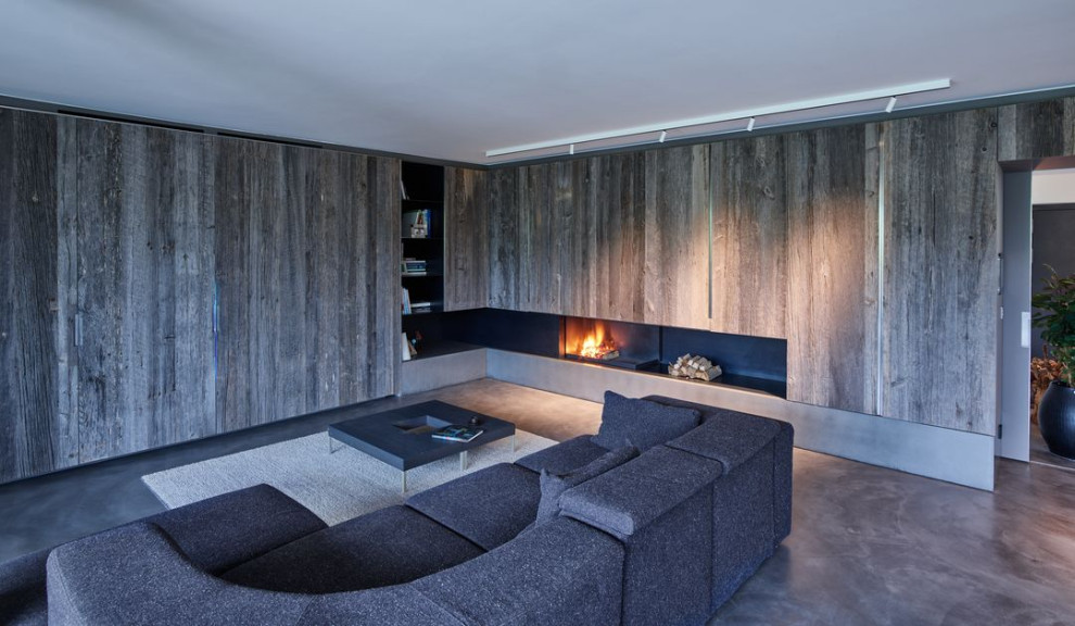 Ispirazione per un soggiorno design aperto con sala formale, pavimento in cemento, cornice del camino in metallo e pavimento grigio