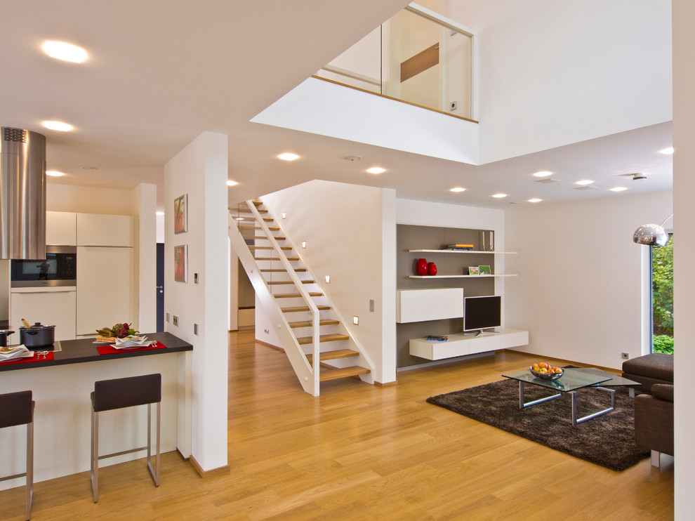 Mittelgroßes, Offenes Modernes Wohnzimmer ohne Kamin mit weißer Wandfarbe, braunem Holzboden und freistehendem TV in Stuttgart