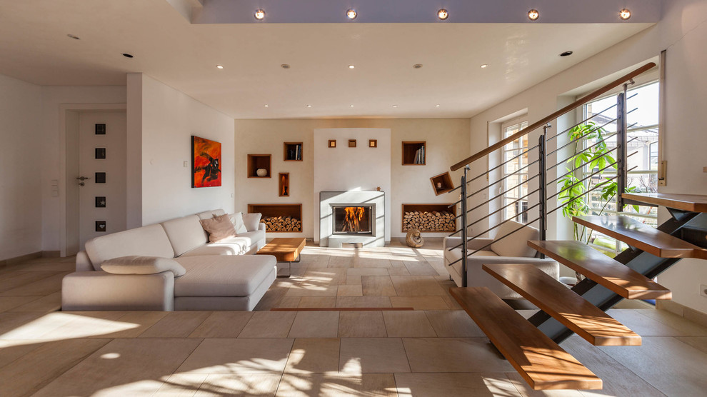 Cette photo montre une salle de séjour tendance ouverte avec un poêle à bois, un manteau de cheminée en plâtre et un mur beige.
