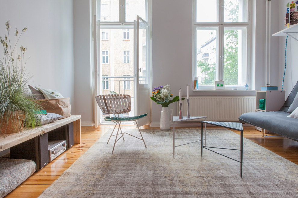 Exemple d'une salle de séjour tendance de taille moyenne avec un mur gris et un sol en bois brun.