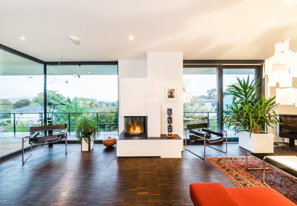 Mid-sized trendy open concept dark wood floor living room photo in Frankfurt with white walls, a standard fireplace, a plaster fireplace and a tv stand