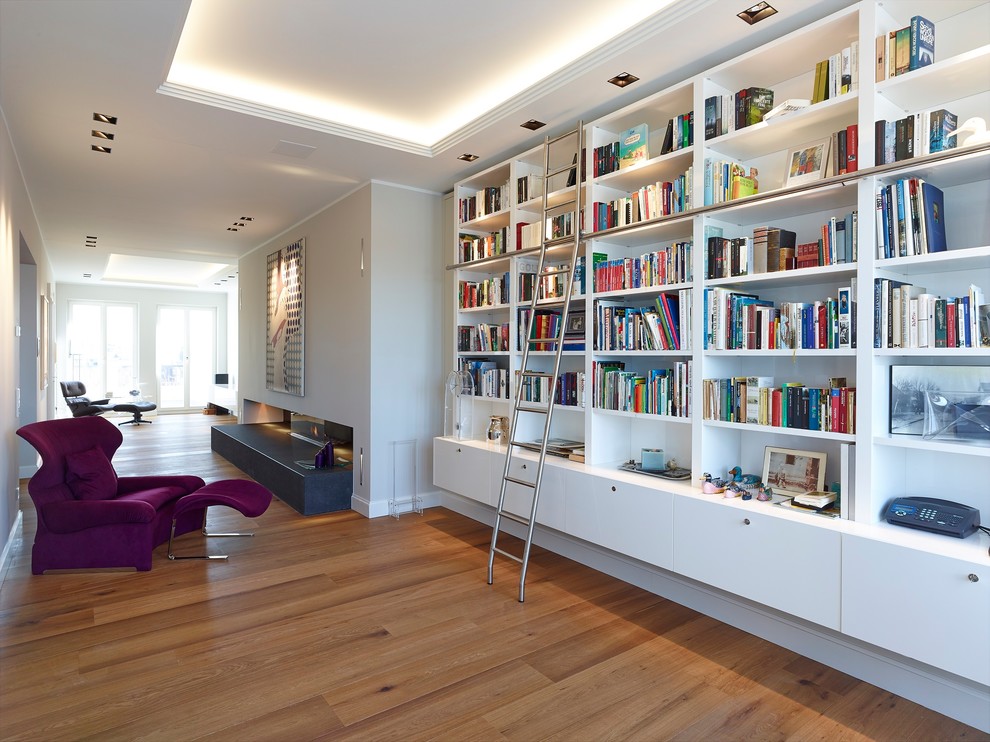Großes, Fernseherloses Modernes Wohnzimmer ohne Kamin mit beiger Wandfarbe, braunem Holzboden und braunem Boden in Düsseldorf