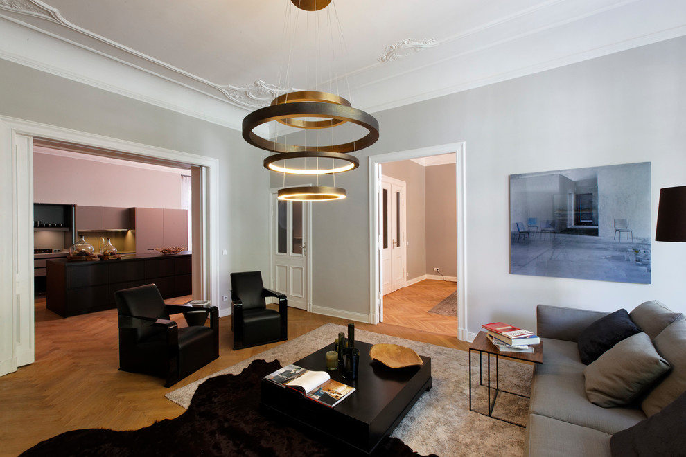 Mittelgroßes, Abgetrenntes Klassisches Wohnzimmer mit grauer Wandfarbe, braunem Holzboden und braunem Boden in Berlin
