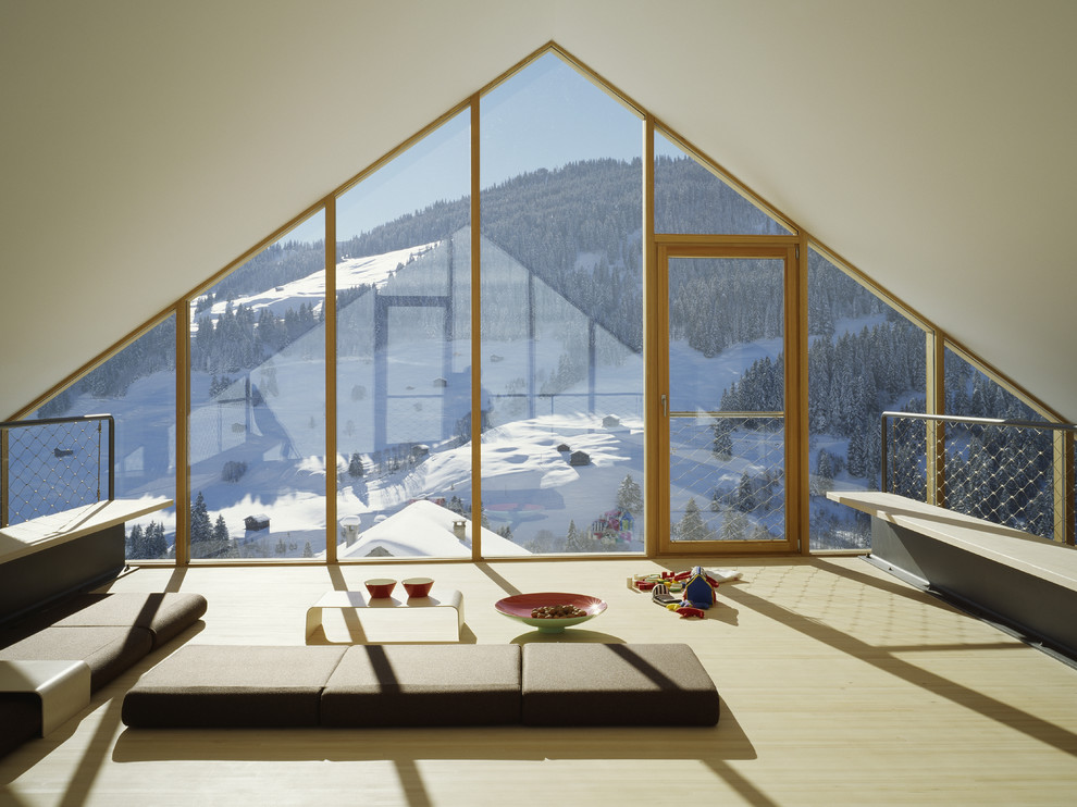 Modelo de sala de estar tipo loft actual con paredes blancas y suelo de madera clara