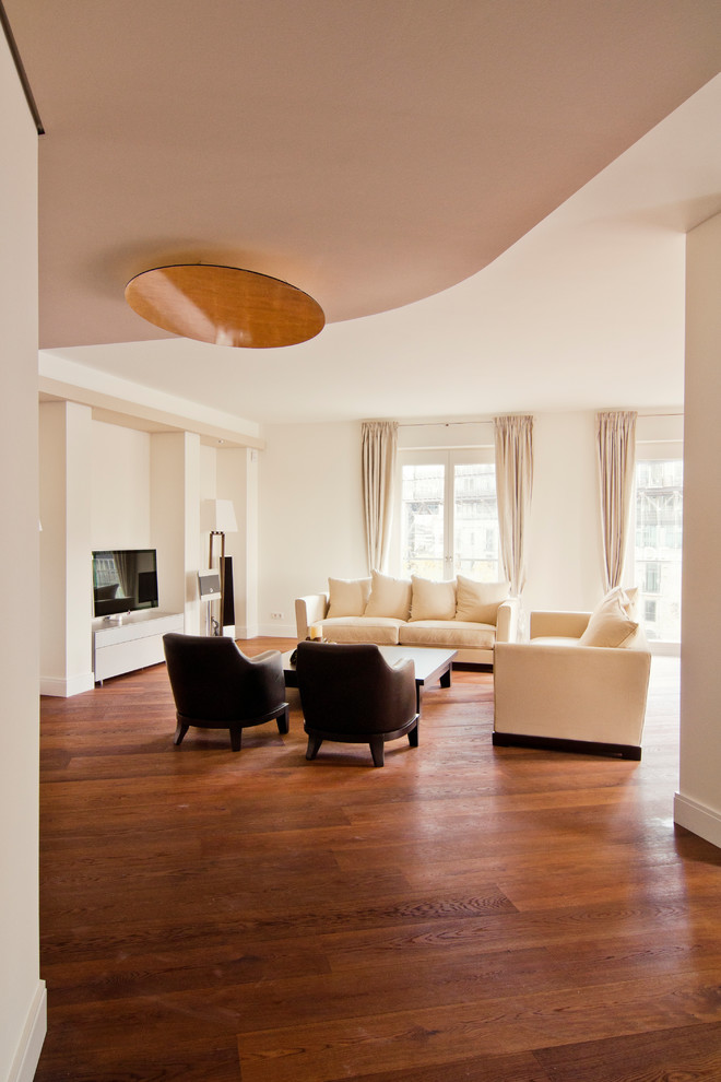 Ejemplo de salón para visitas abierto minimalista con paredes blancas, suelo de madera oscura, televisor independiente y suelo marrón