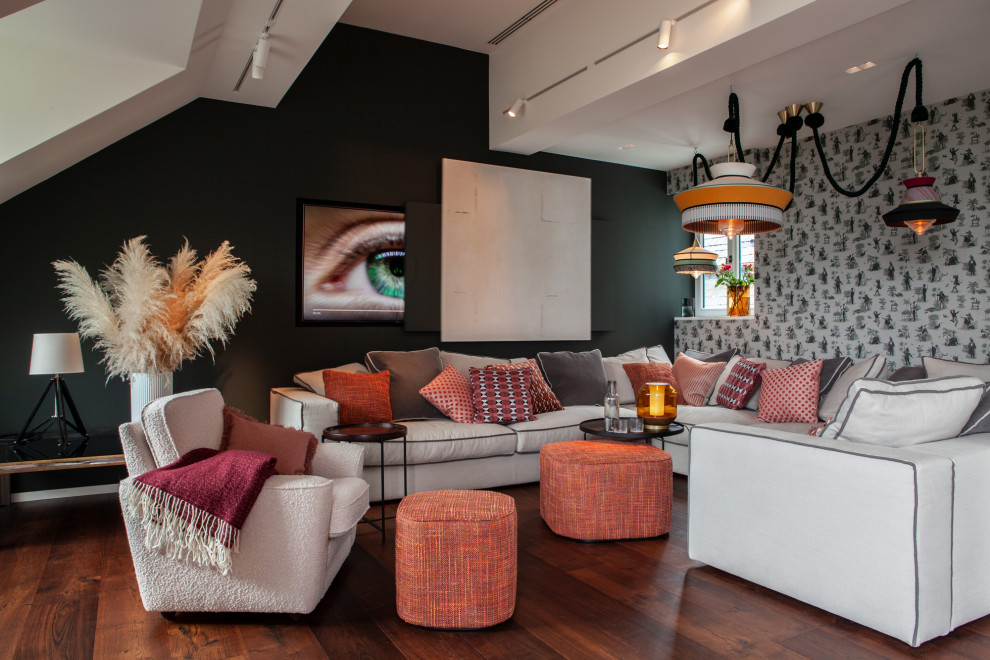 Diseño de sala de estar abierta ecléctica extra grande con televisor retractable, suelo marrón, papel pintado, paredes multicolor y suelo de madera oscura
