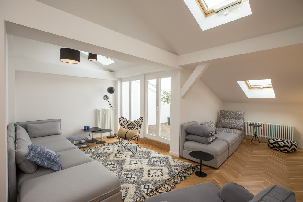 Photo of a scandi living room in Berlin with white walls, medium hardwood flooring and brown floors.