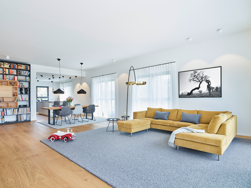 Geräumiges, Offenes Modernes Wohnzimmer in grau-weiß mit weißer Wandfarbe, braunem Holzboden, Eckkamin, TV-Wand und beigem Boden in Frankfurt am Main