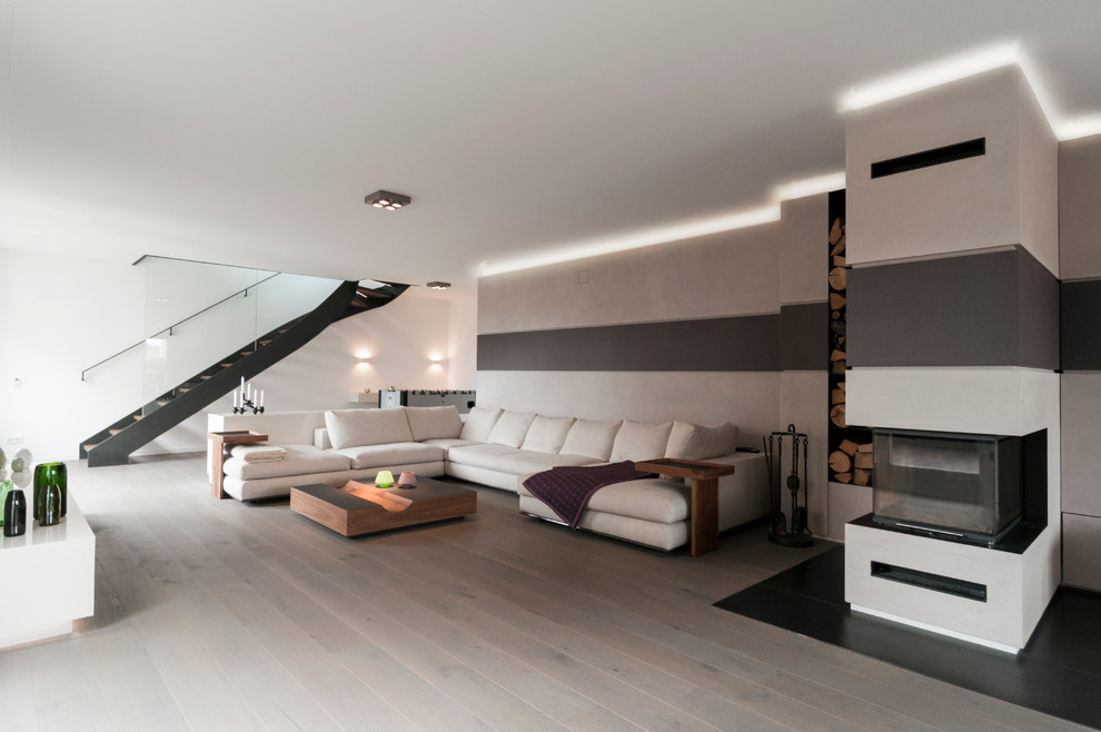 Großes, Repräsentatives, Offenes Modernes Wohnzimmer mit weißer Wandfarbe, hellem Holzboden, Tunnelkamin und verputzter Kaminumrandung in München