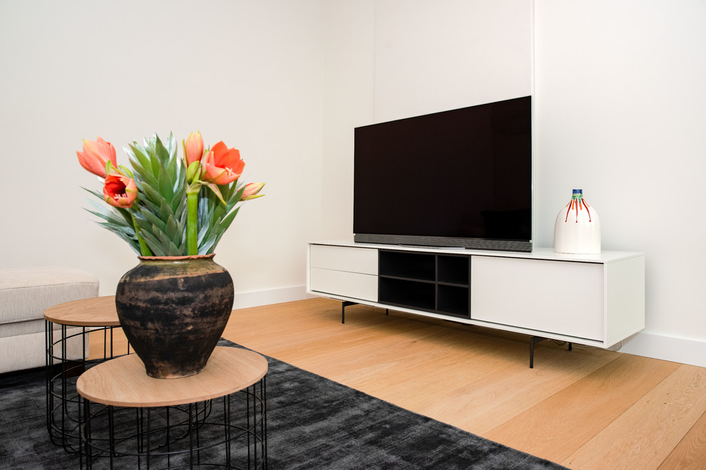 Immagine di un piccolo soggiorno minimalista aperto con parquet chiaro e TV autoportante