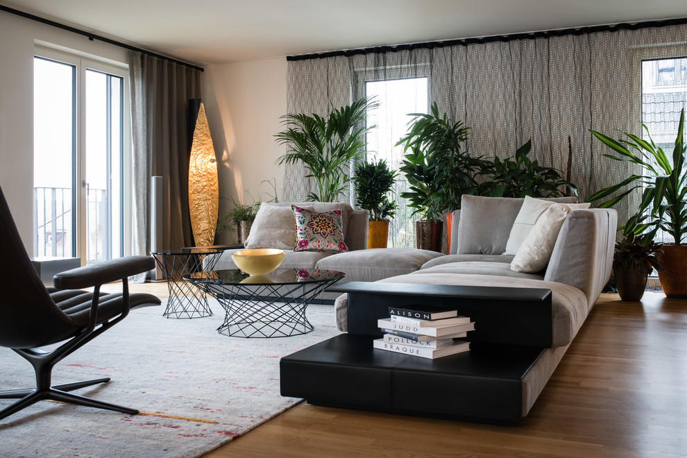 Offenes, Fernseherloses, Geräumiges Modernes Wohnzimmer ohne Kamin mit weißer Wandfarbe, hellem Holzboden und beigem Boden in Stuttgart