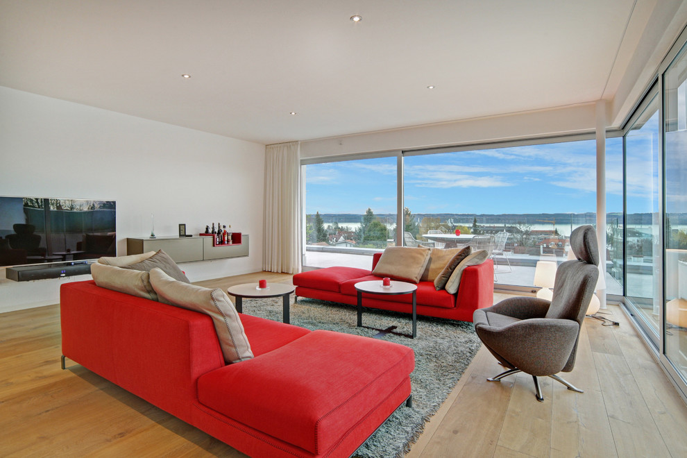 Großes, Repräsentatives Modernes Wohnzimmer ohne Kamin mit weißer Wandfarbe, braunem Holzboden und TV-Wand in München
