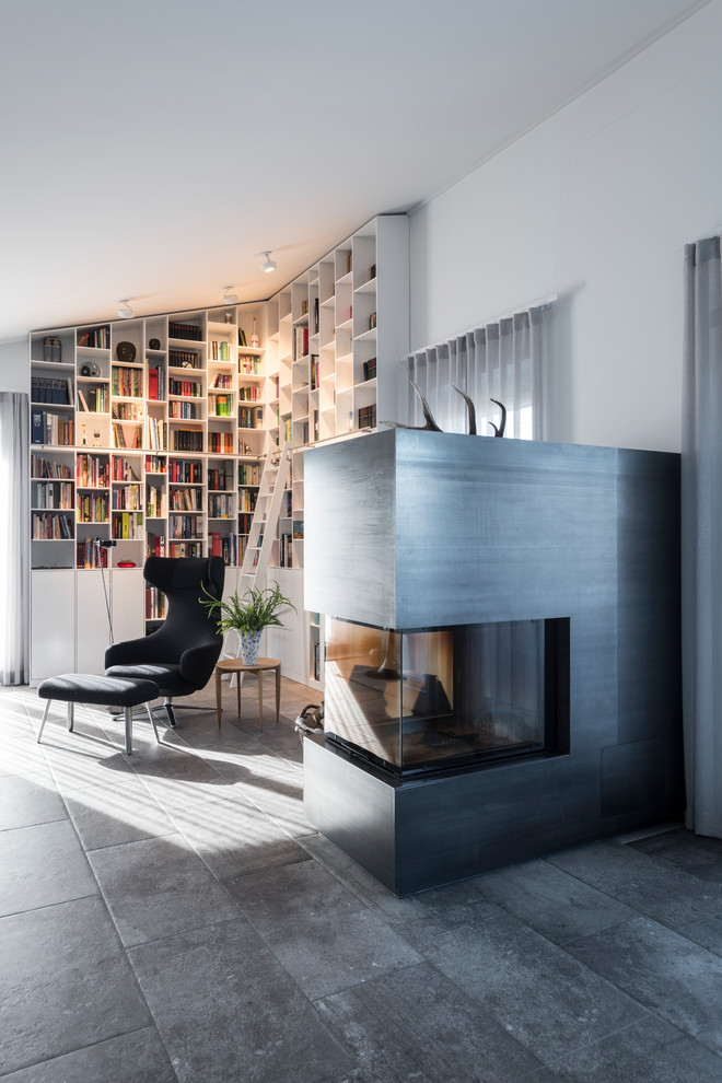 Inspiration för moderna vardagsrum, med vita väggar, en standard öppen spis, grått golv och ett bibliotek