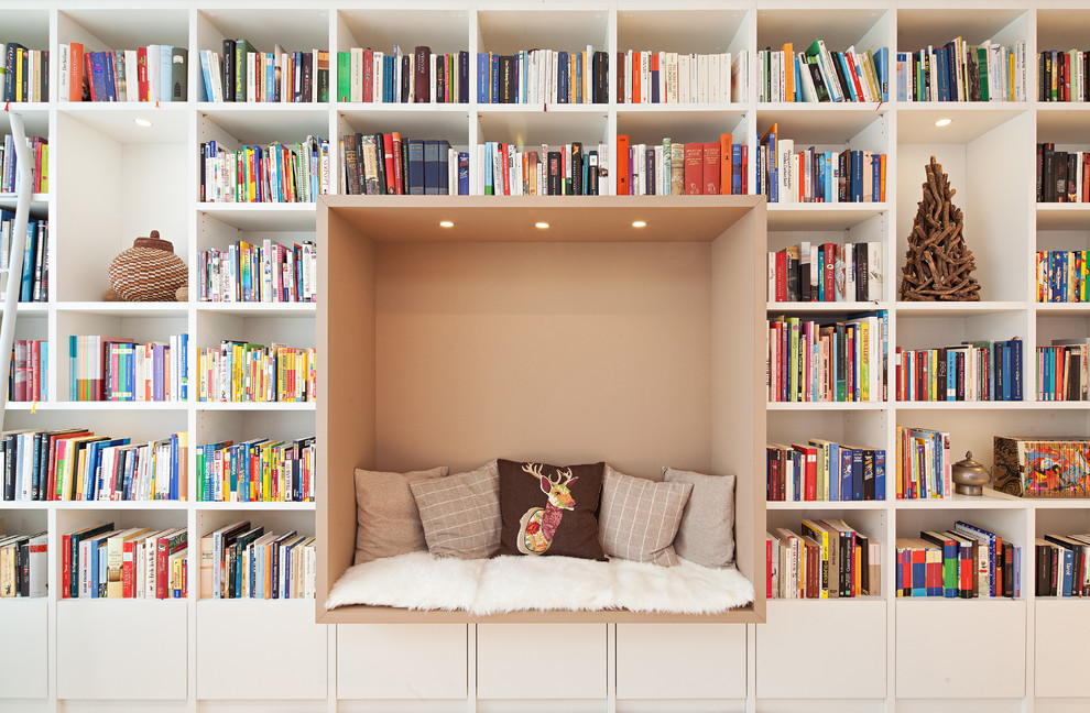 Immagine di un soggiorno design di medie dimensioni con libreria e pareti bianche