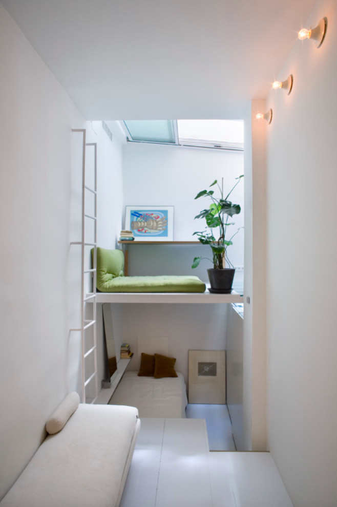 Imagen de sala de estar tipo loft actual pequeña sin chimenea con paredes blancas y suelo de madera pintada