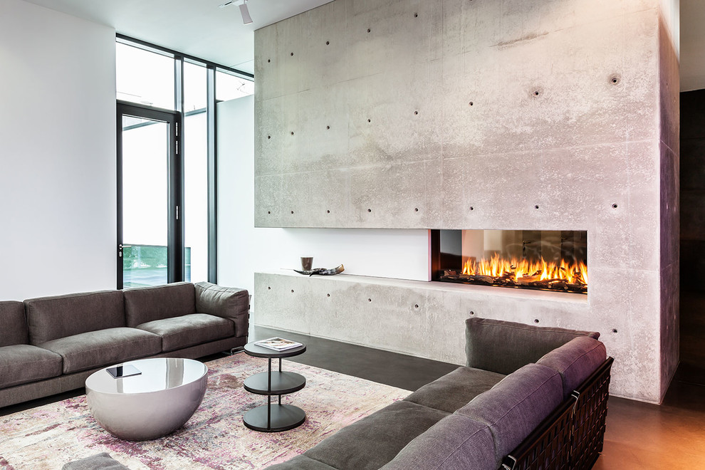 Стильный дизайн: большая открытая, парадная гостиная комната в современном стиле с белыми стенами, двусторонним камином, фасадом камина из бетона и полом из линолеума без телевизора - последний тренд