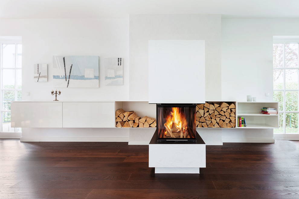 Inspiration for a mid-sized contemporary dark wood floor living room remodel in Dortmund with white walls, a two-sided fireplace and a plaster fireplace