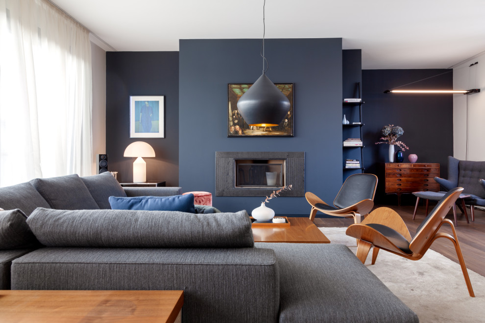 Foto di un grande soggiorno contemporaneo aperto con sala formale, pareti blu, camino classico, cornice del camino in metallo, nessuna TV e pavimento marrone