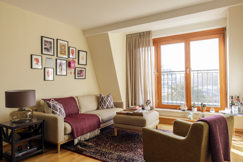 Kleines, Fernseherloses, Offenes Klassisches Wohnzimmer ohne Kamin mit beiger Wandfarbe, Hausbar und hellem Holzboden in Berlin