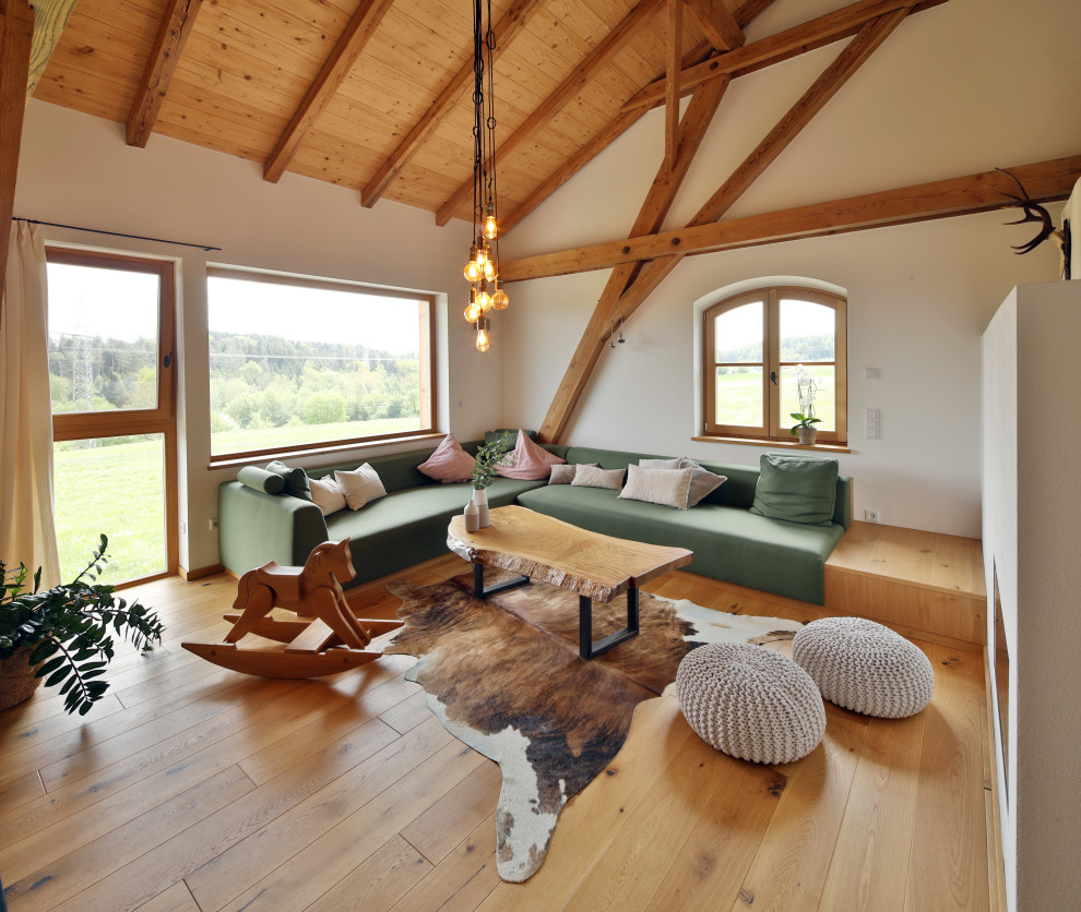Idee per un soggiorno country aperto con pareti bianche, pavimento in legno massello medio, pavimento marrone, travi a vista, soffitto a volta e soffitto in legno
