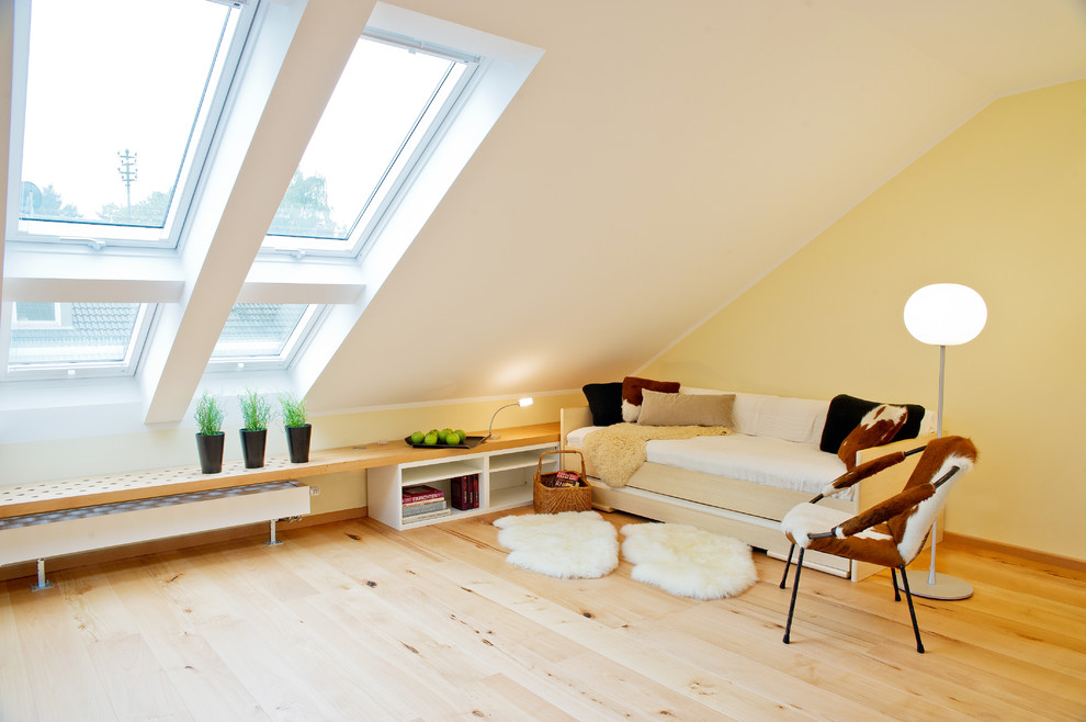 Mittelgroßes, Fernseherloses Nordisches Wohnzimmer ohne Kamin mit gelber Wandfarbe und hellem Holzboden in München