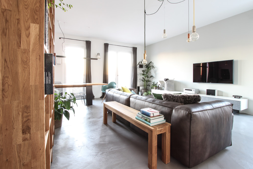 Свежая идея для дизайна: открытая гостиная комната среднего размера в скандинавском стиле с серыми стенами, бетонным полом и телевизором на стене - отличное фото интерьера