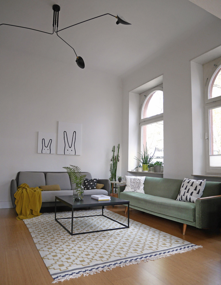 Ejemplo de sala de estar cerrada contemporánea de tamaño medio sin chimenea y televisor con paredes blancas, suelo de madera en tonos medios y suelo marrón