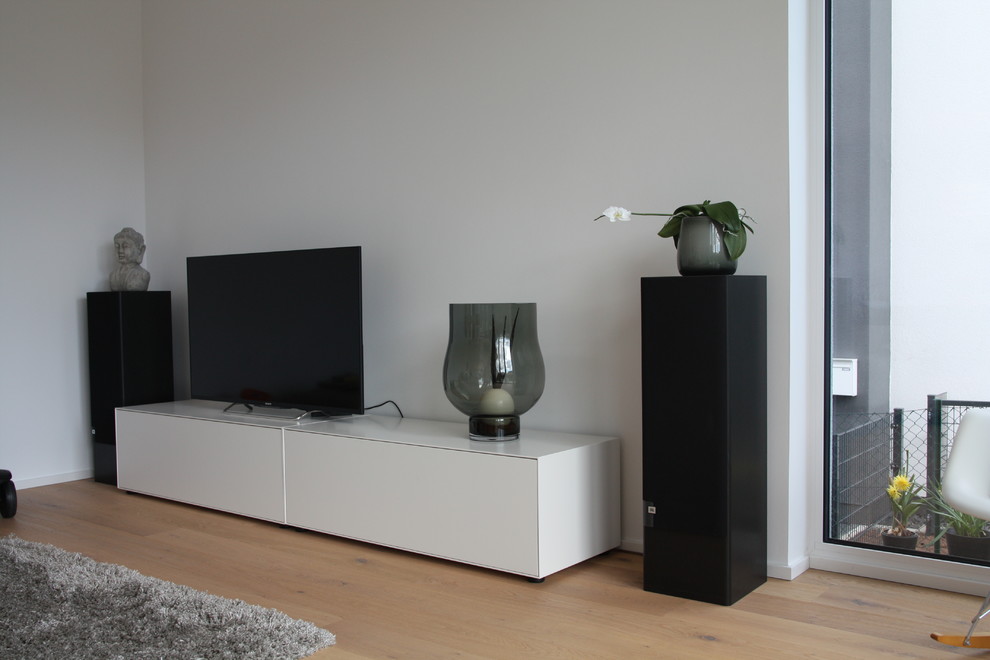 Mittelgroßes, Offenes Modernes Wohnzimmer mit weißer Wandfarbe, hellem Holzboden und freistehendem TV in Frankfurt am Main
