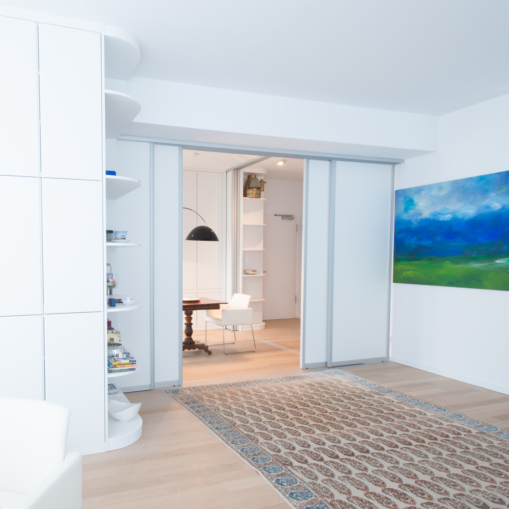 Esempio di un piccolo soggiorno contemporaneo con pareti bianche e parquet chiaro