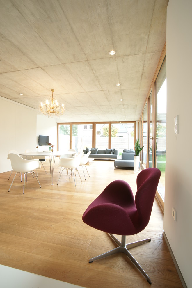 Kleines, Repräsentatives, Offenes Nordisches Wohnzimmer mit weißer Wandfarbe und braunem Holzboden in Düsseldorf