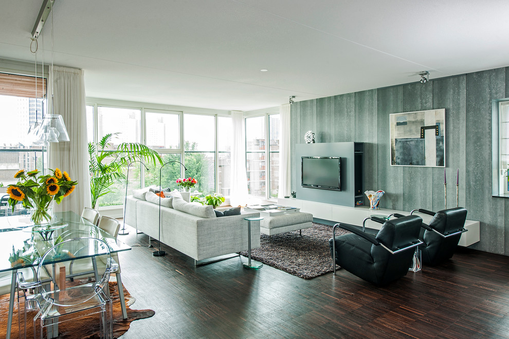 Geräumiges, Offenes Modernes Wohnzimmer mit grauer Wandfarbe, dunklem Holzboden und Multimediawand in Sonstige