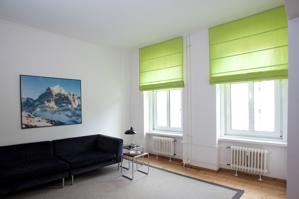 Idée de décoration pour un salon minimaliste ouvert avec un mur blanc et un sol en bois brun.