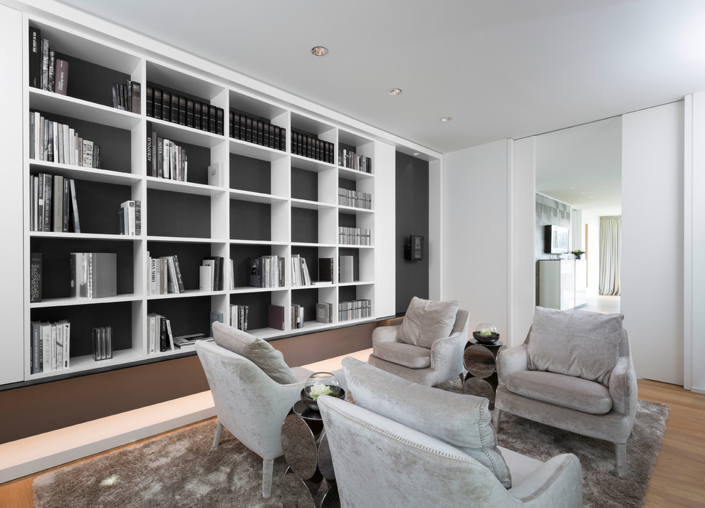 Idéer för ett mellanstort modernt separat vardagsrum, med ett bibliotek, vita väggar, mellanmörkt trägolv och brunt golv